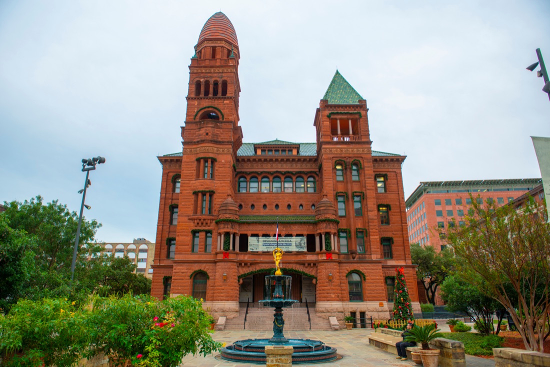 Red-sandstone-building clock-tower fountain romanesque-architecture
